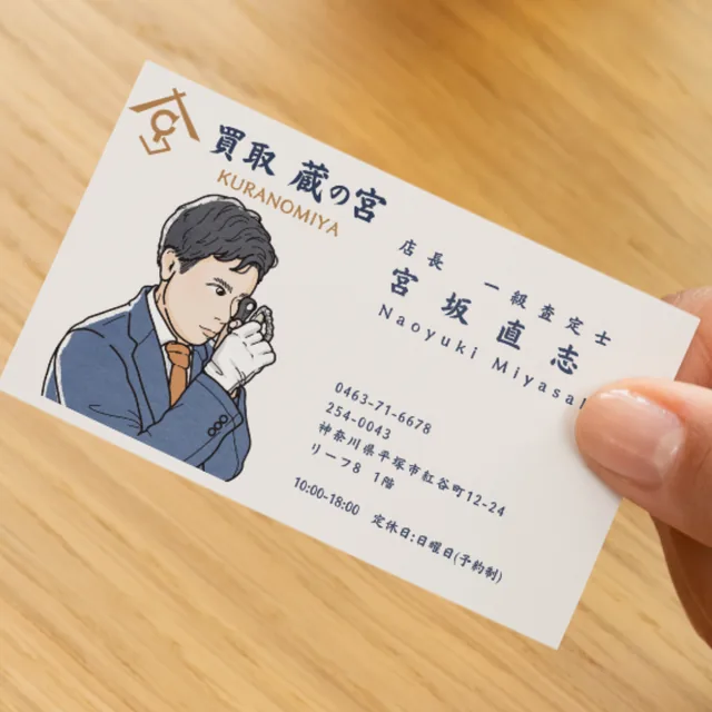 買取 蔵の宮の名刺。ルーペで品物を見る店主の線画イラストと、店名・連絡先