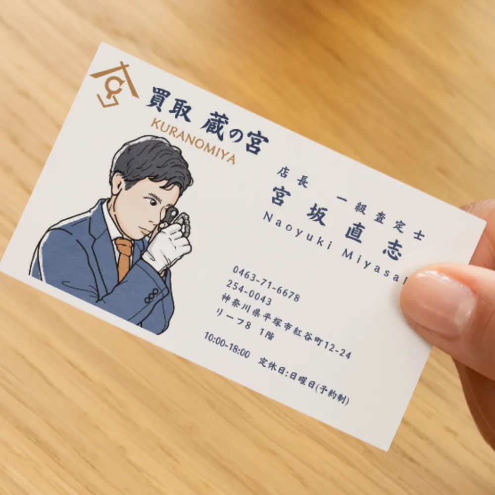 買取 蔵の宮の名刺。ルーペで品物を見る店主の線画イラストと、店名・連絡先